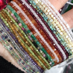 Macro shot of 2-3mm faceted natural crystal beads in amethyst and various gemstones