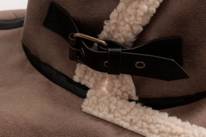 Close-up of vintage suede jacket featuring metal buckle straps and faux shearling lining