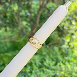 Macro shot of 18K gold plated U-shaped ring with cubic zirconia on white stand