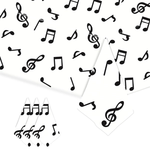 Detail of white paper napkins with black musical note patterns for party table decor