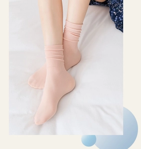 Close-up of pink velvet ice silk slouch socks with ribbed texture worn in a cozy setting