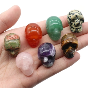 Set of seven mini 1-inch carved natural crystal skull figurines held in hand