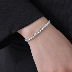 Close-up of sparkling square-cut zircon tennis bracelet worn on a woman wrist