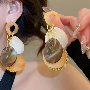 Detail showing vintage acrylic fringe earrings with multi-color geometric resin layers