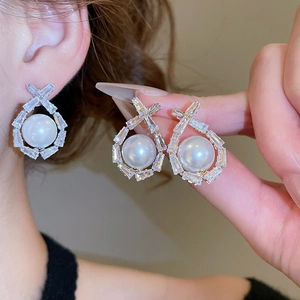 Detailed close-up of water-drop pearl earrings with baguette-cut cubic zirconia accents