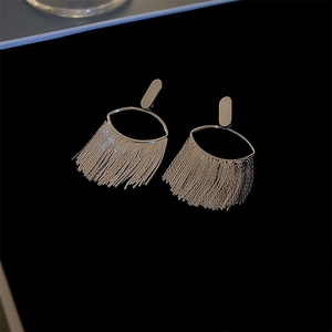 Detail of silver geometric fringe earrings with metal tassels on a dark background