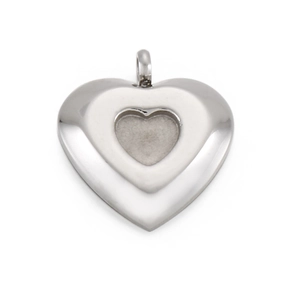 Close-up of a silver heart pendant with inner groove and glossy stainless steel finish
