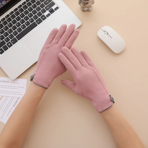 Pink velvet thermal touchscreen gloves for women with checkered bow on a desktop