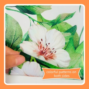 Close-up of double-sided floral window sticker showing green leaves and white flowers
