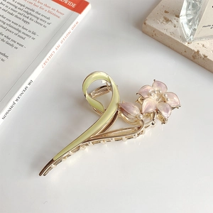Detailed close-up of a floral metal hair claw with pink enamel flowers and pearls