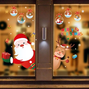 Christmas window decals with Santa, reindeer and gold baubles on a glass shop storefront