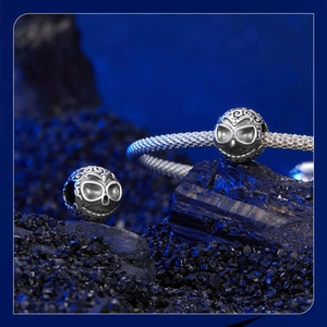 Macro detail of S925 sterling silver skull charm on a textured bracelet for Halloween jewelry
