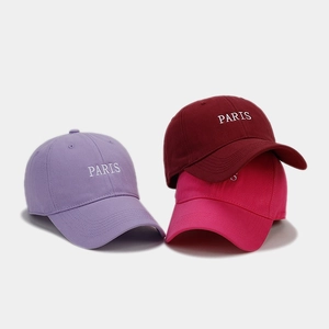 Detail showing embroidered PARIS logo on purple, burgundy and rose red cotton baseball caps