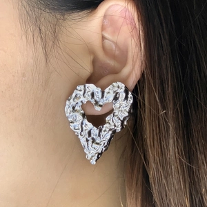 Boucles d'oreilles cœur en argent avec texture martelée portées sur l'oreille