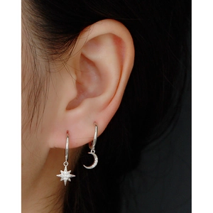 Macro view of S925 sterling silver hoop earrings with moon and star diamond pendants
