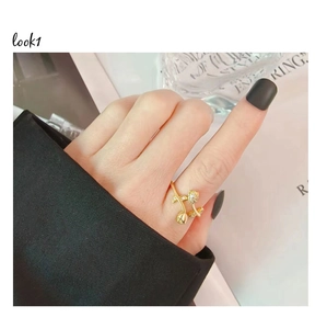 Detailed view of a gold tulip ring with sparkling diamonds worn on a finger