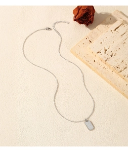 Macro detail of silver rectangular pendant set with sparkling cubic zirconia on a fine chain