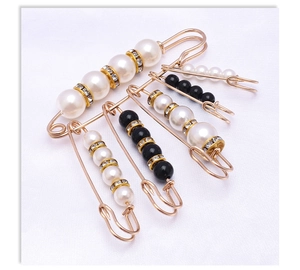 Detailed view of gold waist pins set with white pearls and sparkling crystal spacers