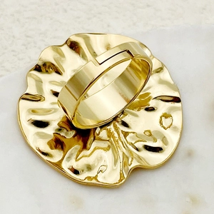 Macro shot of gold-plated adjustable ring featuring irregular hammered texture and leaf edges