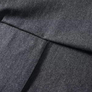 Vue macro du tissu gris foncé épais et détails des coutures sur la jupe longue évasée