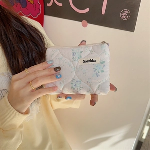 Detailed shot of floral quilted cotton pouch with zipper and soft fabric texture