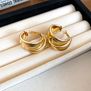Detailed view of layered gold hoop earrings presented in a jewelry display box