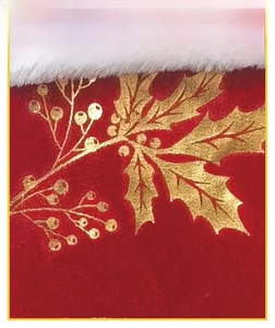 Macro shot of red velvet Christmas stocking with golden holly leaf pattern and white fur