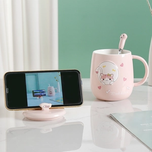 Pink ceramic cat mug with lid and spoon featuring a 3D kitten motif and phone holder lid
