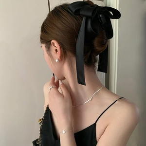 Barrette à cheveux nœud en satin noir avec boucles d'oreilles perles et bijoux portés