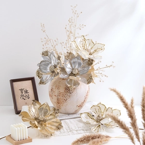 Elegant gold and silver Christmas artificial flowers in a vintage ceramic vase for decor