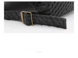 Close-up of black crocodile pattern faux leather baseball cap with bronze metal buckle