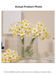 Artificial white daffodils with yellow centers in a striped glass vase on a checkered cloth