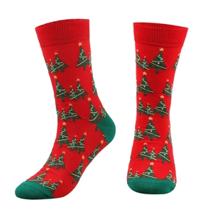 Detail of red Christmas crew socks with green accents and festive tree patterns