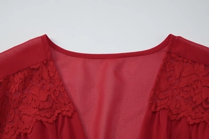 Détail des coutures en dentelle rouge et de l'élégant col en V sur la zone de l'épaule