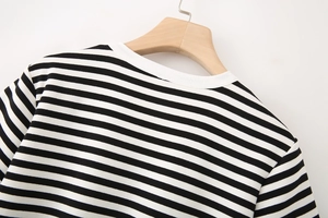 Close-up of the round neckline and striped fabric texture on a wooden hanger