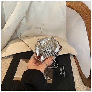 Macro shot of silver fish-shaped evening bag with metallic texture and crystal diamond detail