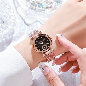Close-up of rose gold watch with black starry dial and diamond markers on female wrist