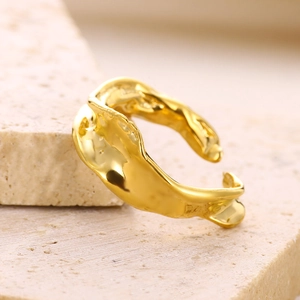 Macro shot of gold irregular lava ring with molten liquid metal texture and adjustable band