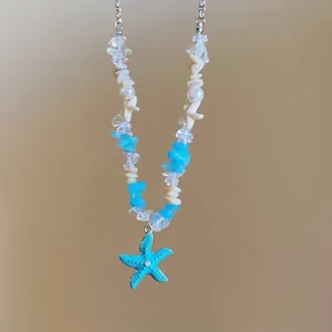 Detail of starfish charm necklace with blue stone beads and white pearls for summer beach wear