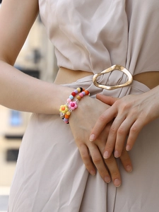 Detail of colorful matte floral beads bracelet set on woman's wrist with boho style