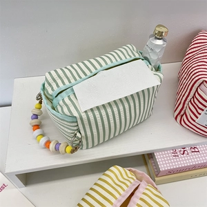 Detail of green striped fabric tissue holder with decorative colorful beaded handle