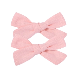 Set of two pink linen cotton bow hair clips for girls on a clean white background