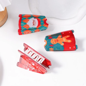 Three Christmas hair claws featuring Santa Claus and Gingerbread Man patterns in festive colors