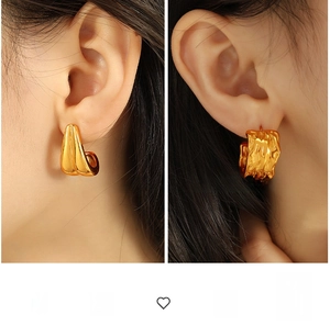 Detail of 18K gold pleated texture and smooth C-shaped hoop earrings on model