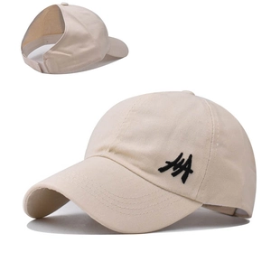 Close-up of beige ponytail baseball cap featuring a large back opening and side embroidery