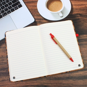 A5 cork texture notebook set with pen on wood desk with coffee and laptop top view