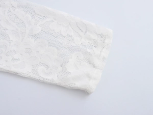 Close-up of intricate floral lace texture and embroidery on the white shirt sleeve