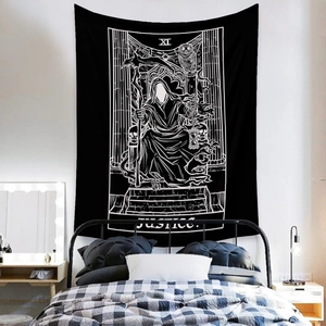 Detail of black and white Tarot Justice tapestry hanging on a minimalist bedroom wall