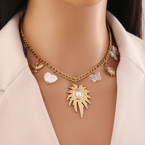 Collana in acciaio dorato con ciondoli sole, farfalla e perla indossata da una modella