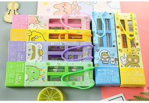 Overhead view of five colorful 5-in-1 stationery gift sets with cute cartoon patterns